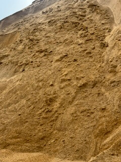 Sandy backfill material for utility trenches