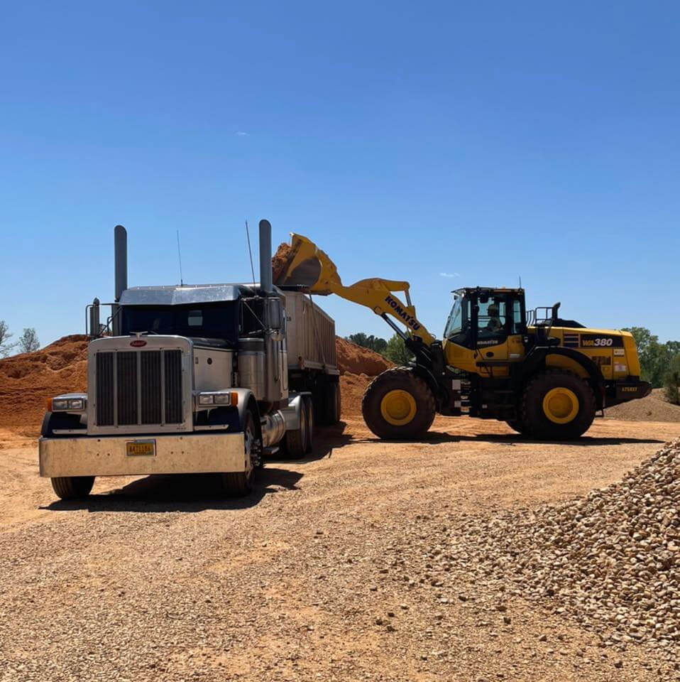 Loader filling a dump truck with material for delivery at Magnolia Sand & Gravel